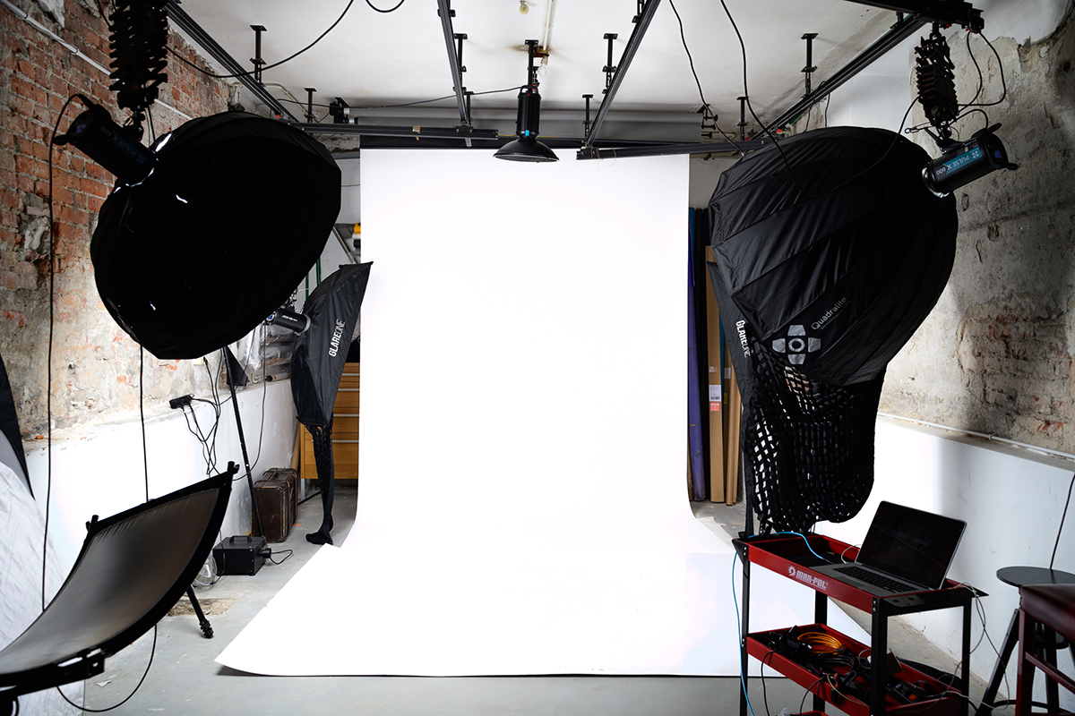 Wnętrze studia fotograficznego z białym tłem i lampami błyskowymi z softboksami